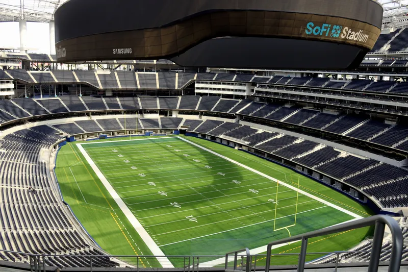 The empty seating bowl and field at SoFi Stadium beneath the canopy-hung video board